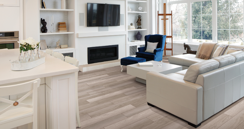 A living room with a couch , chair , television and fireplace.