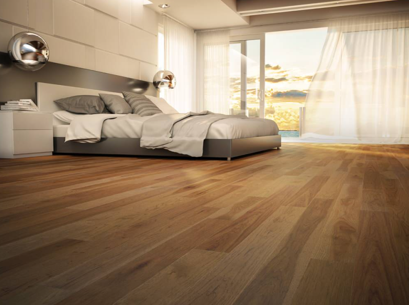 A bedroom with a large bed and a wooden floor.