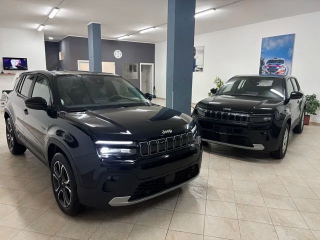 Vista frontale sinistra di un SUV blu scuro con faro circolare illuminato e dettagli della griglia all'interno
