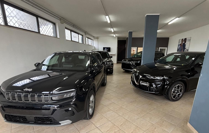 Interni di auto moderni con display sul cruscotto, volante e console centrale in nero e argento.