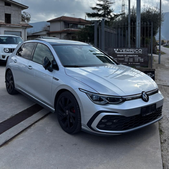 Primo piano della griglia anteriore e del cofano di una Jeep grigia in uno showroom.