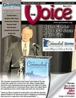 A man in a suit is speaking into a microphone on the cover of a magazine.