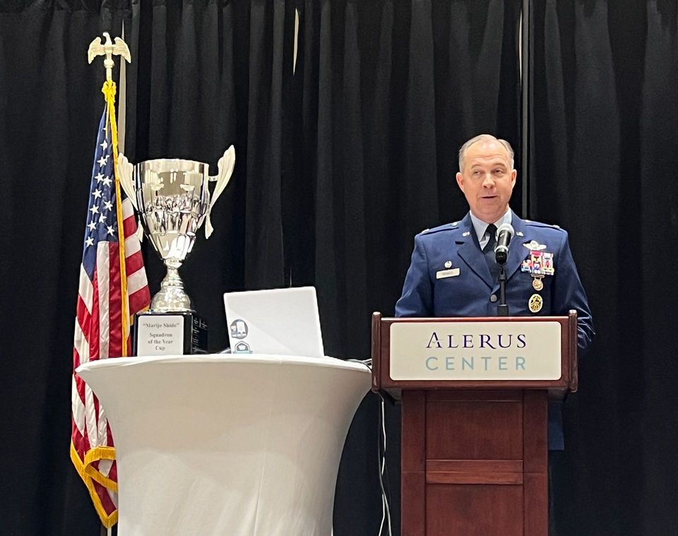A man in a military uniform is standing at a podium giving a speech.