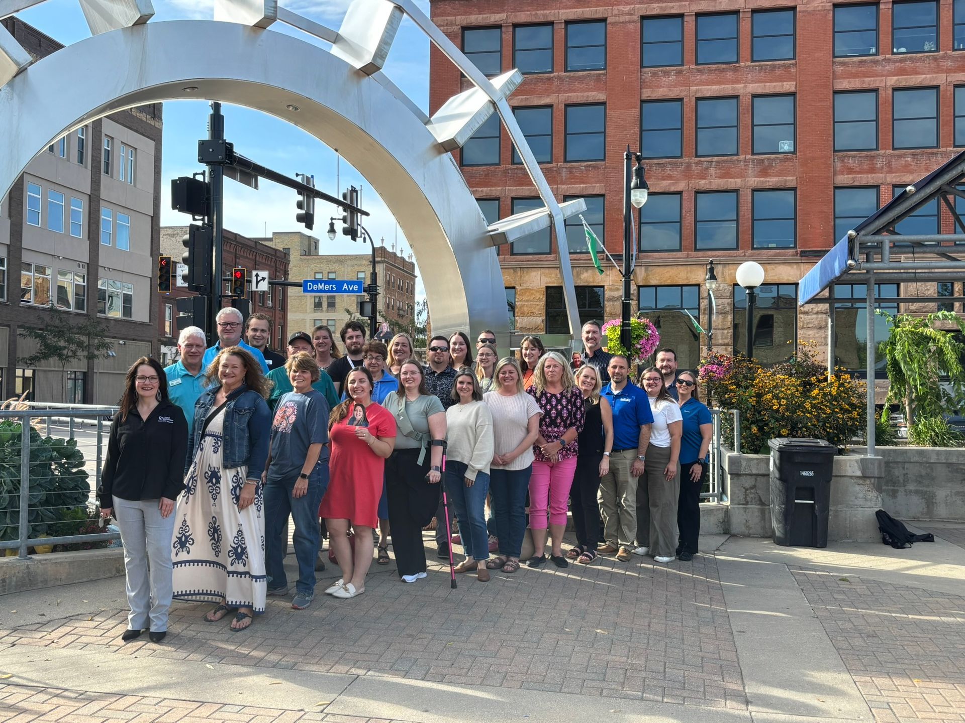 A group of people are posing for a picture in front of a bridge.