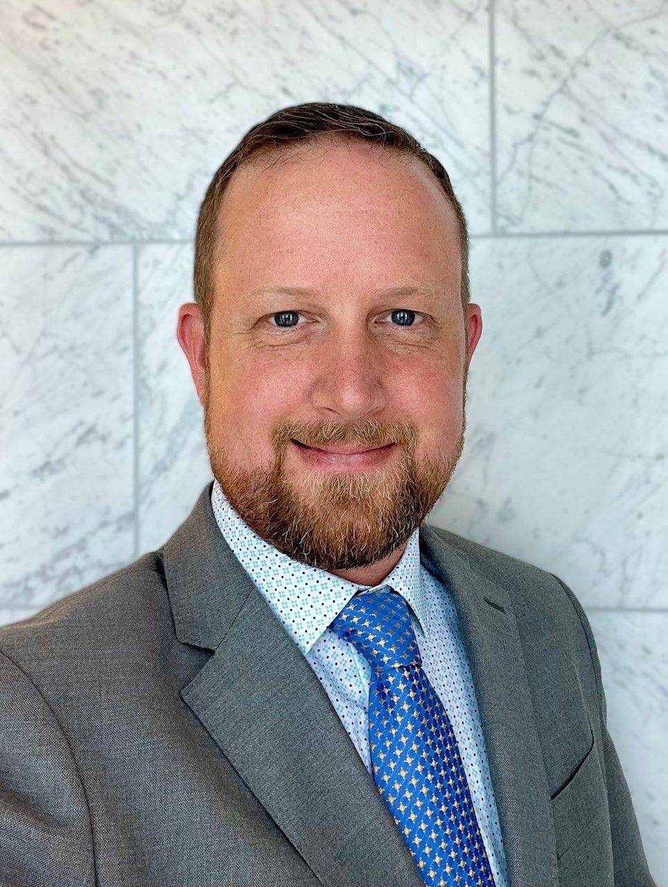 A man in a suit and tie is smiling for the camera.
