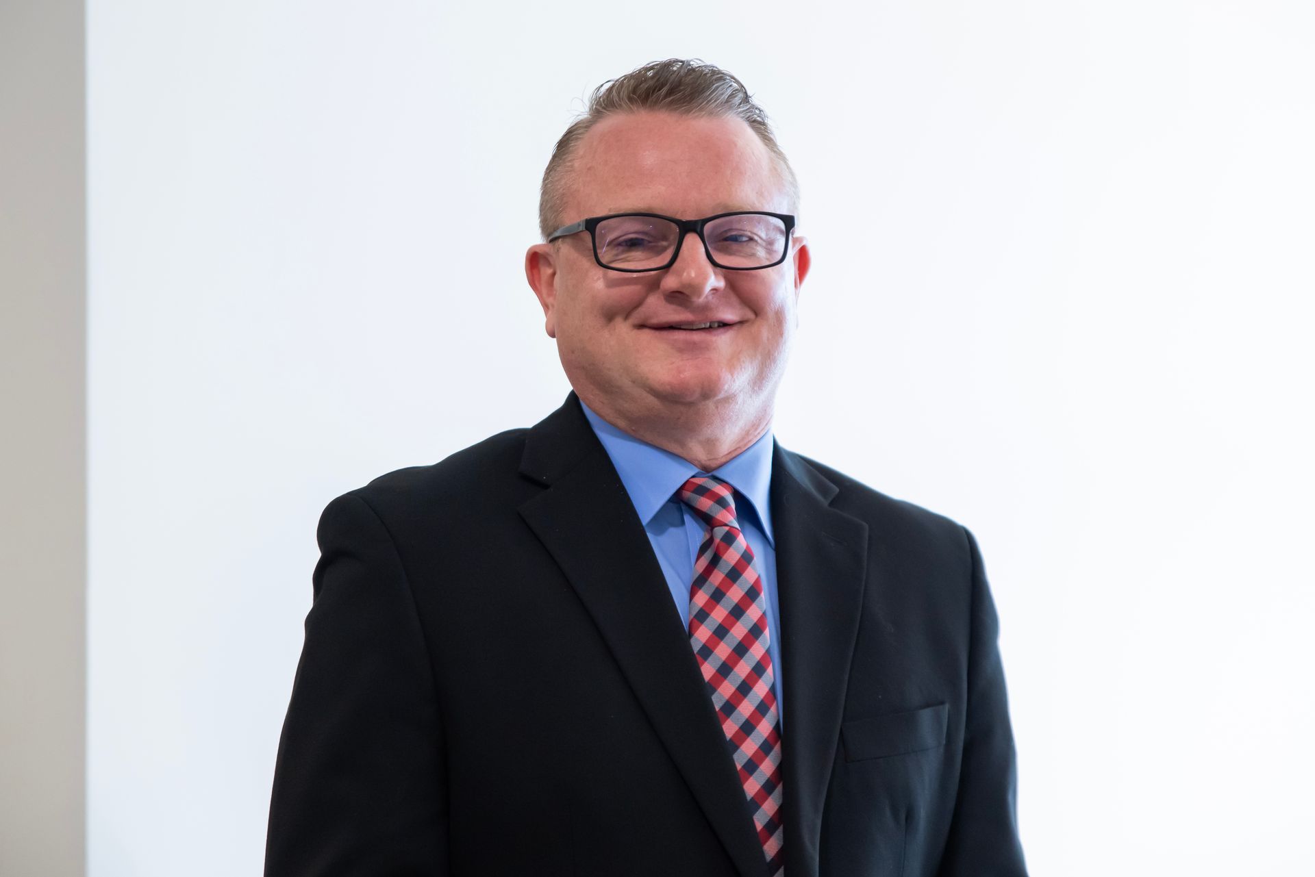 A man in a suit and tie is smiling for the camera.