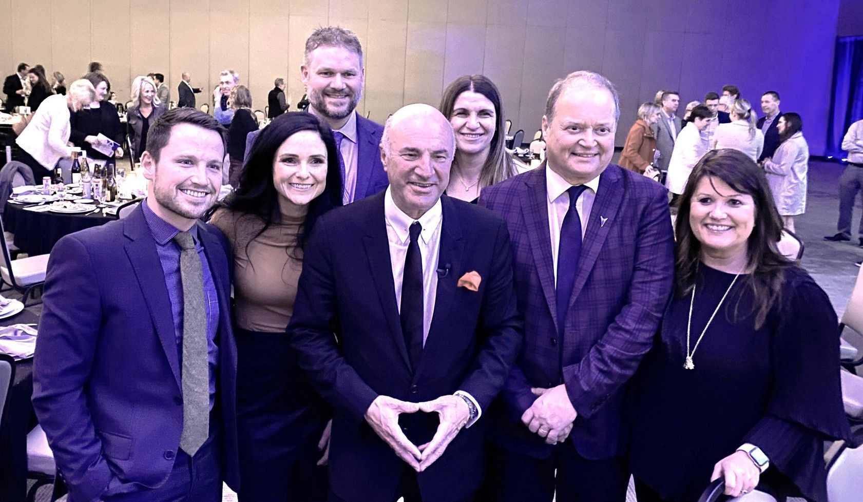 A group of people in suits and ties are posing for a picture.