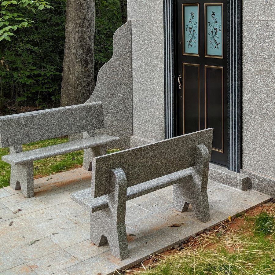 The entrance to a private granite family mausoleum with etched glass doors and two granite benches, built by Gaulden Monuments