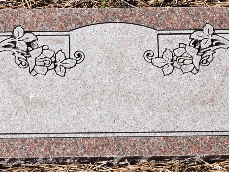 Close view of a blank Morning Rose granite flat grave marker with carved rose corners