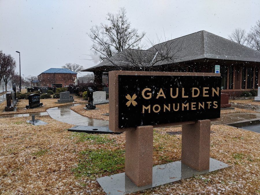 The Gaulden Monuments roadside sign at the Rock Hill showroom, with granite monuments standing in the display yard behind it