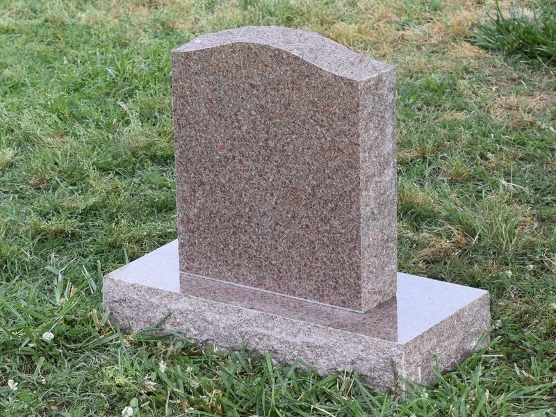 A small Morning Rose granite upright headstone with a serpentine top on a matching base