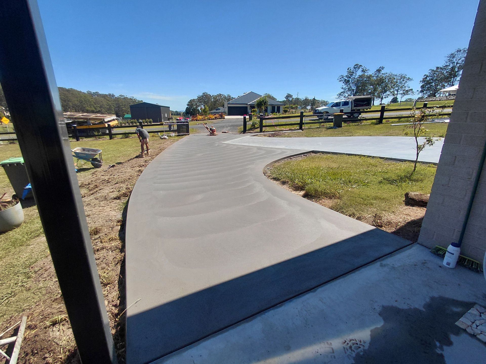 Curved Concrete Walkway Through a Fenced Rural Park Under a Clear Blue Sky — Kempsey Concrete Contractors PTY LTD In Dondingalong, NSW