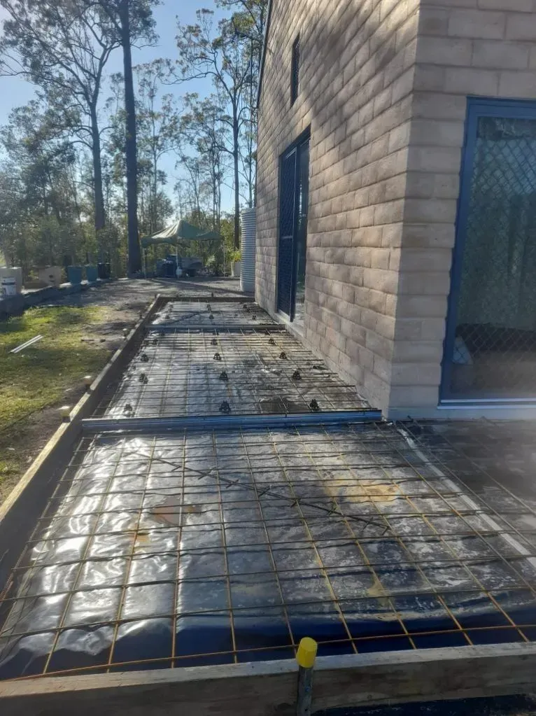 Concrete Walkway Under Construction Beside a Tan Brick Building — Kempsey Concrete Contractors PTY LTD In Dondingalong, NSW