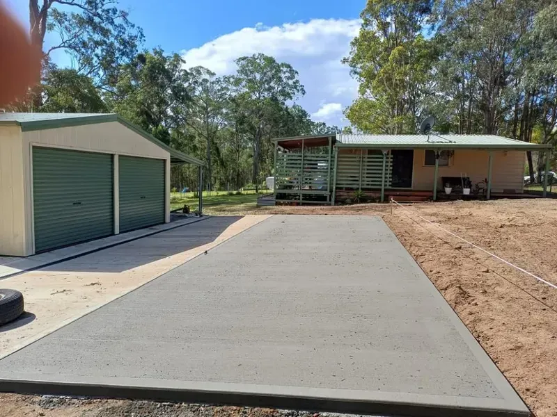 Concrete Driveway Leading to A Small House and Garage in A Wooded Rural Setting — Kempsey Concrete Contractors PTY LTD In South West Rocks, NSW