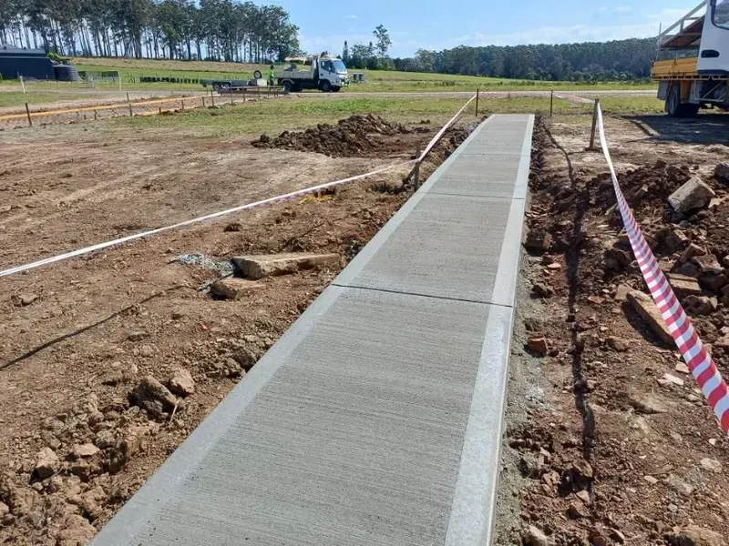 Fresh Concrete Sidewalk Under Construction in A Dirt Field — Kempsey Concrete Contractors PTY LTD In Port Macquarie, NSW
