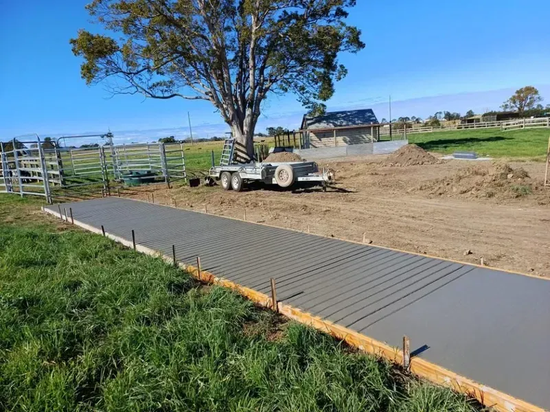 New Concrete Sidewalk Beside a Dirt Construction Site — Kempsey Concrete Contractors PTY LTD In Nambucca Heads, NSW