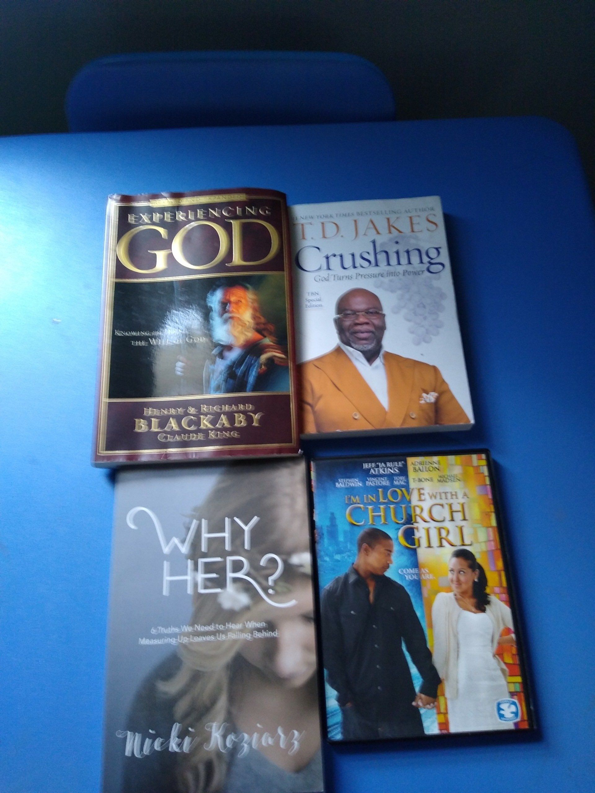 Four books and a DVD on a blue surface. Titles include 