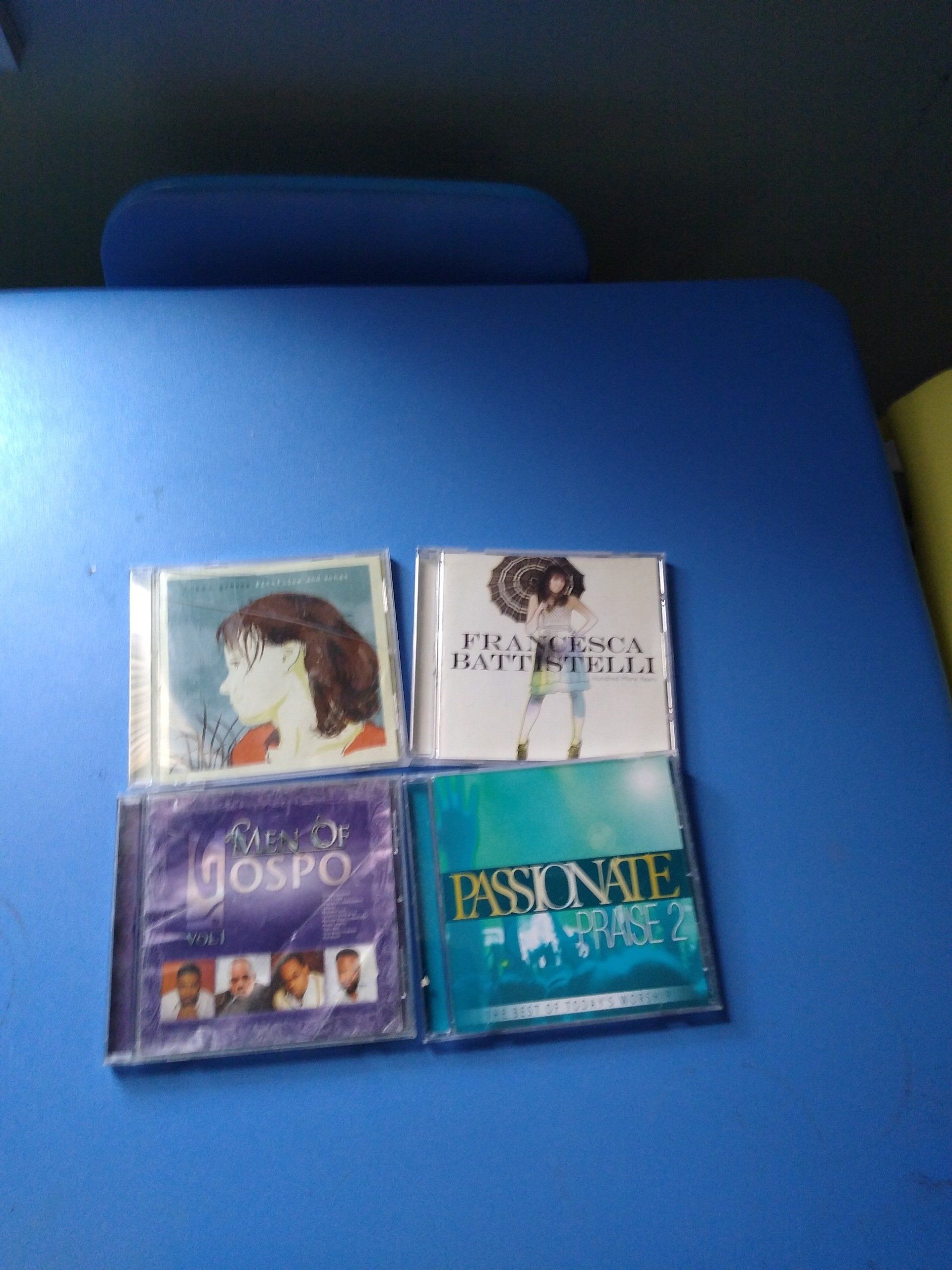 Four CD albums on a blue surface.
