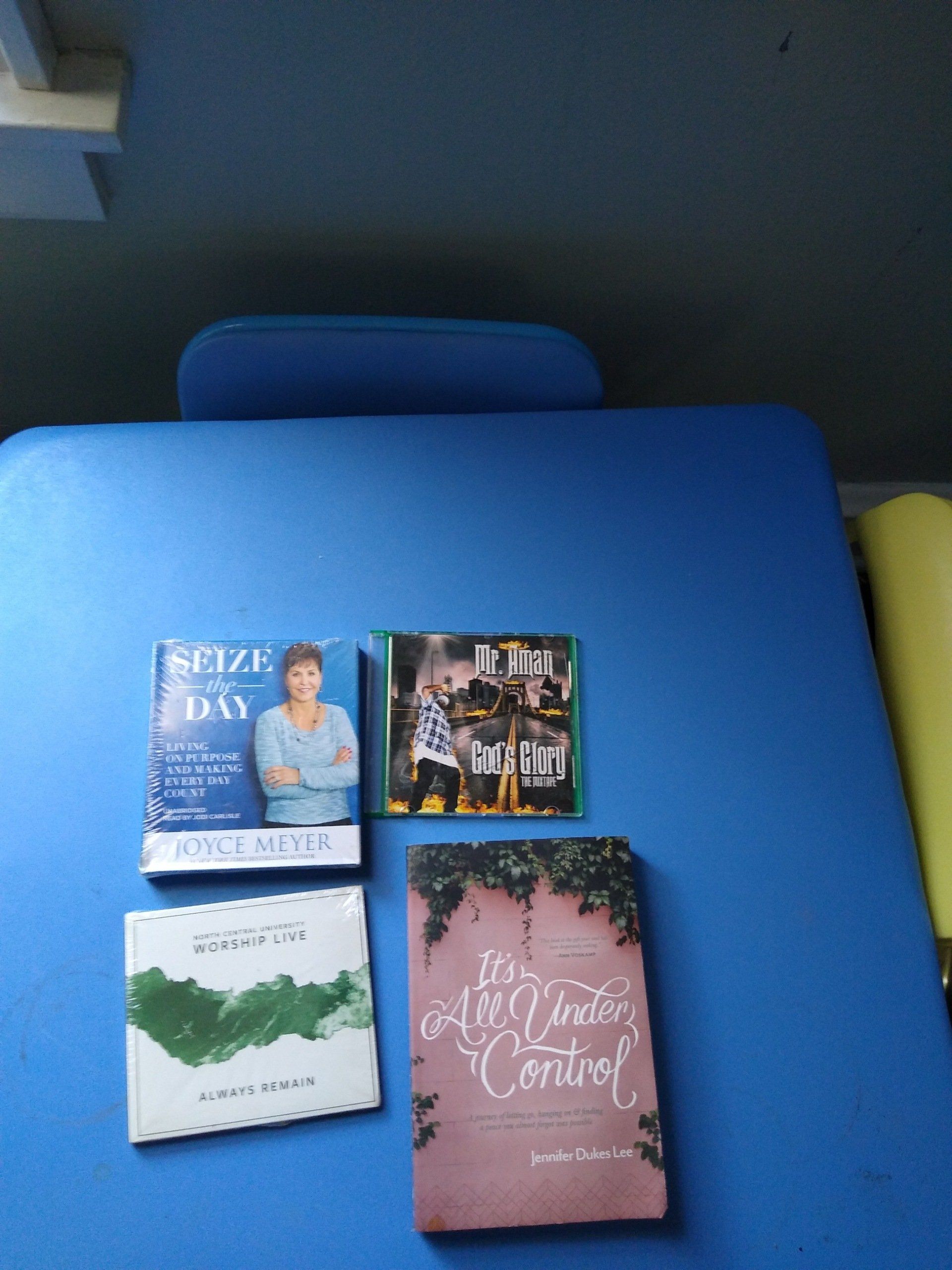 Four CDs and a book on a blue surface; covers include text and images.