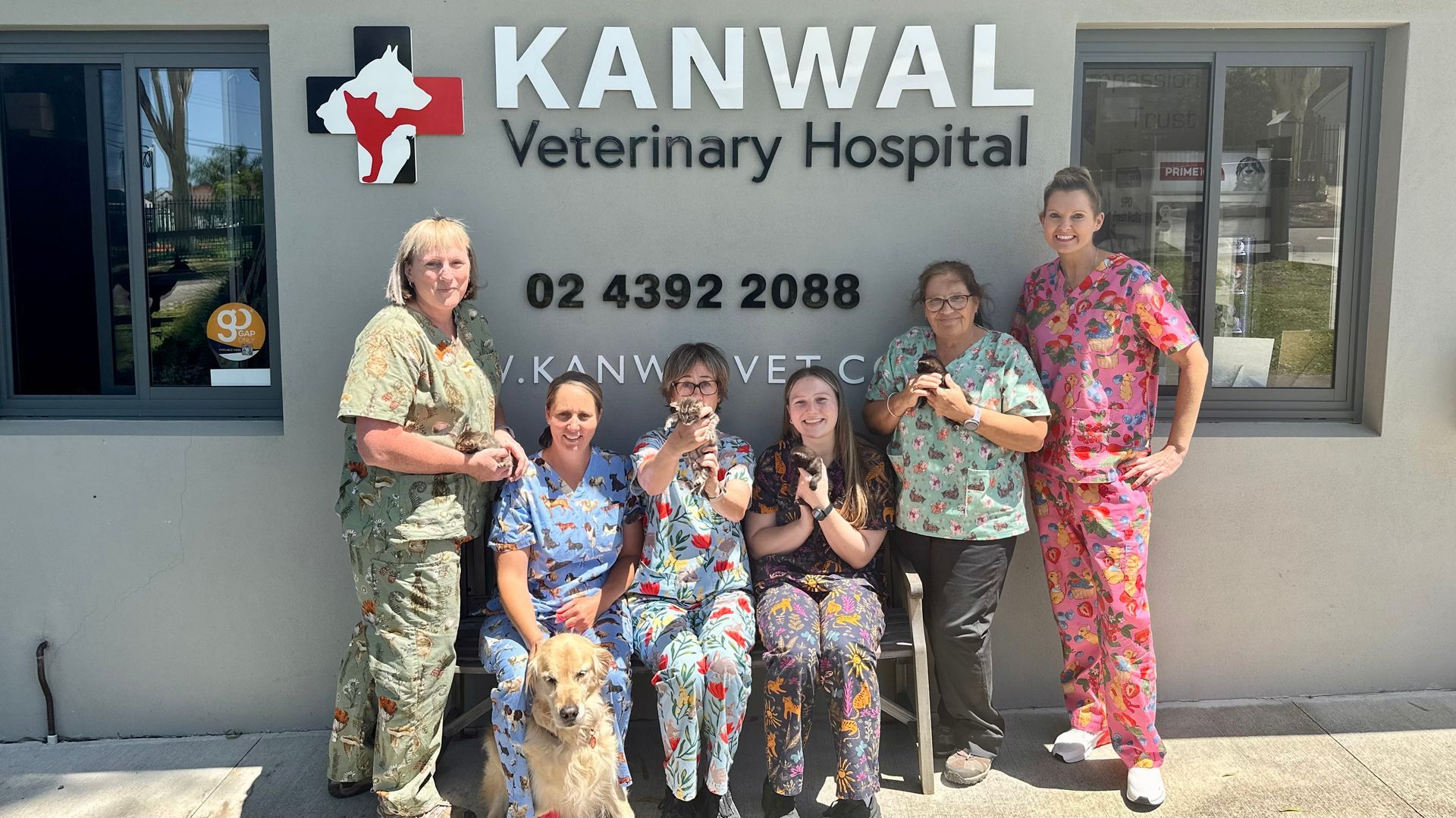 A group of people posing for a picture in front of kanwal veterinary hospital — Kanwal Veterinary Hospital In Kanwal, NSW