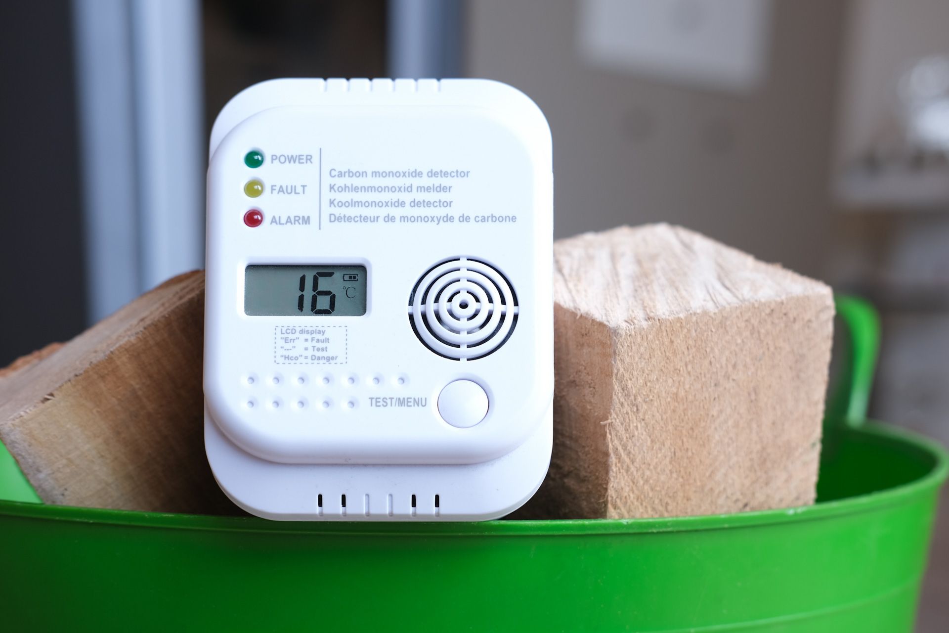 A carbon monoxide detector is sitting in a green bucket