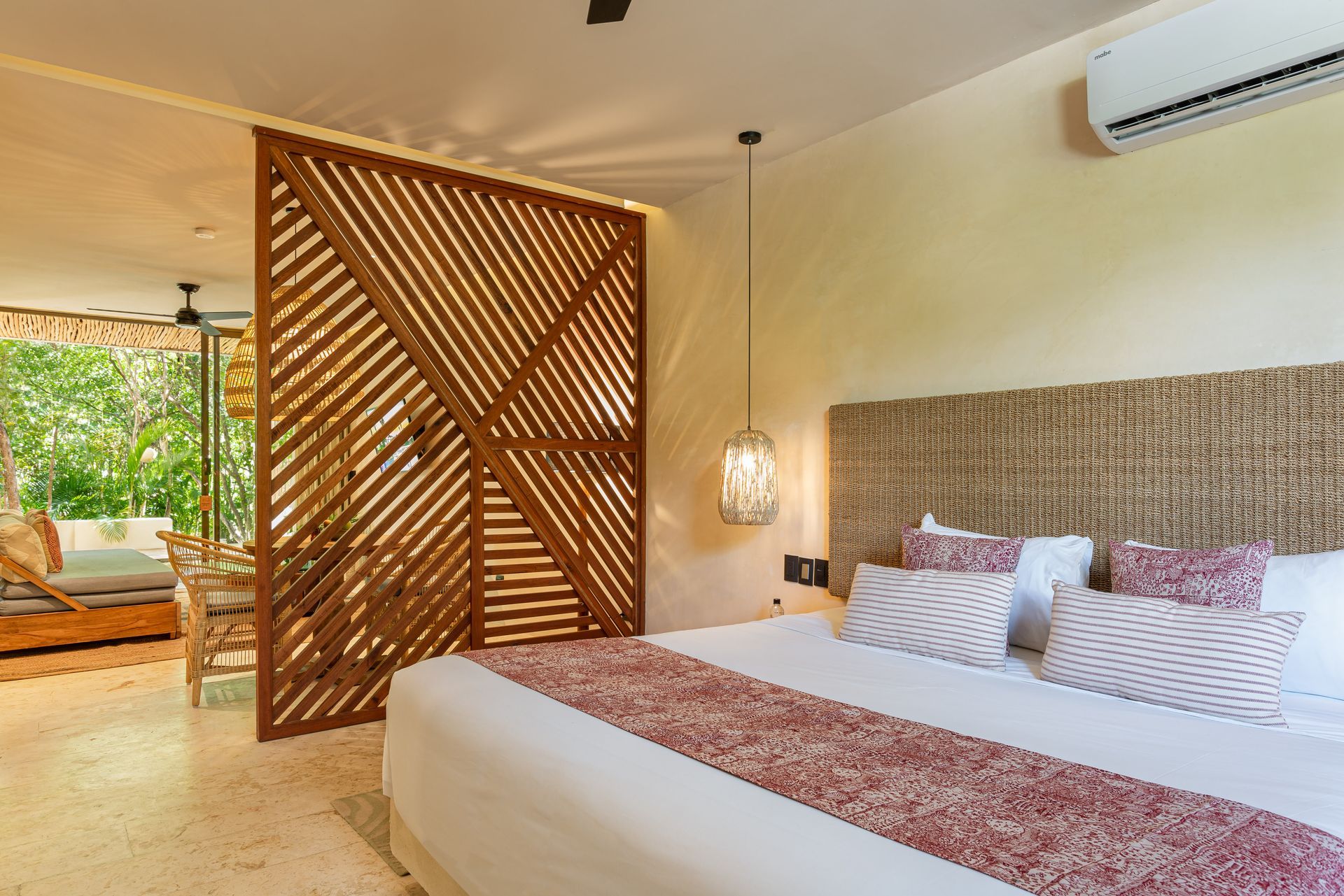 A bedroom with a king size bed and a wooden divider.