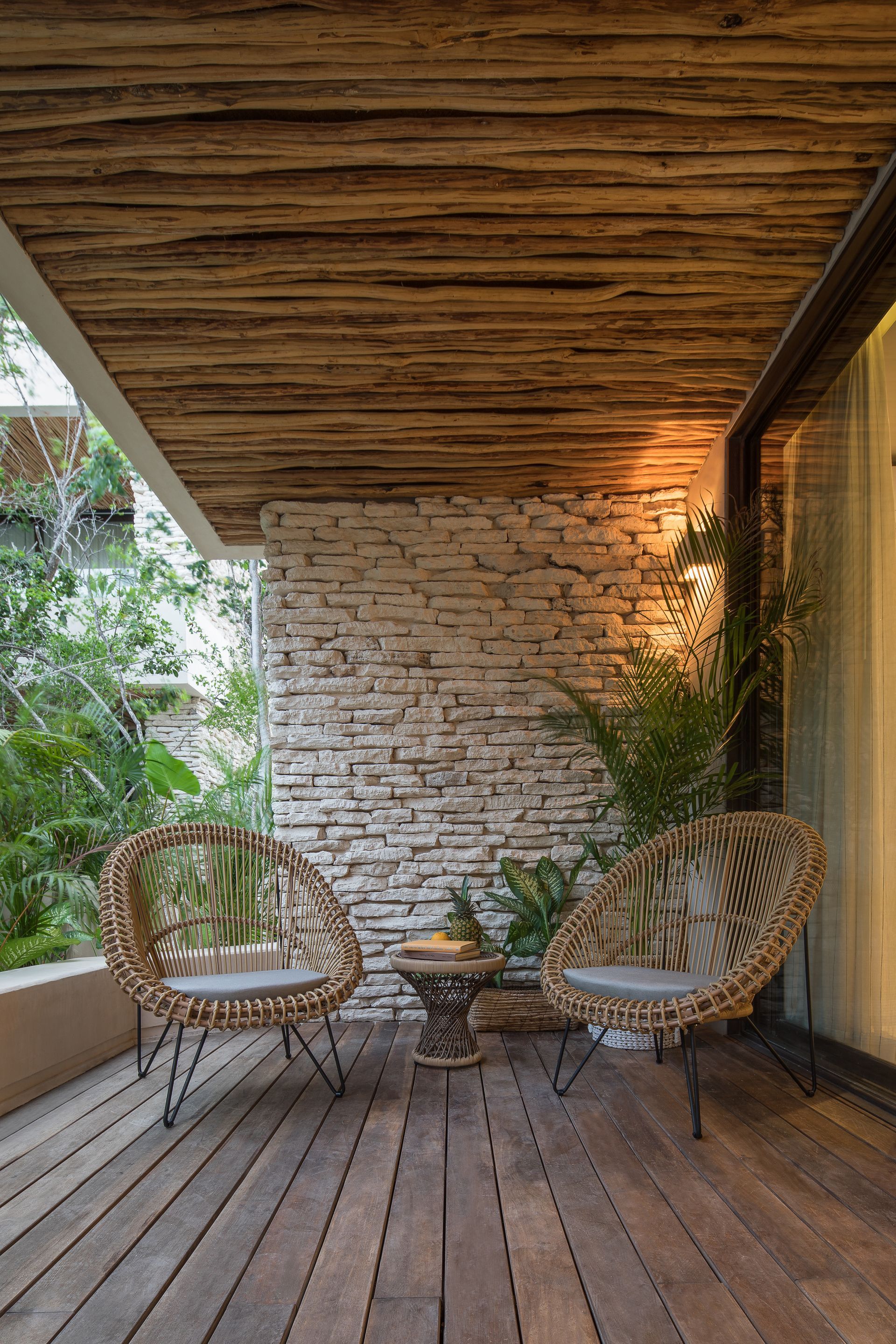 There are two chairs and a table on the deck.