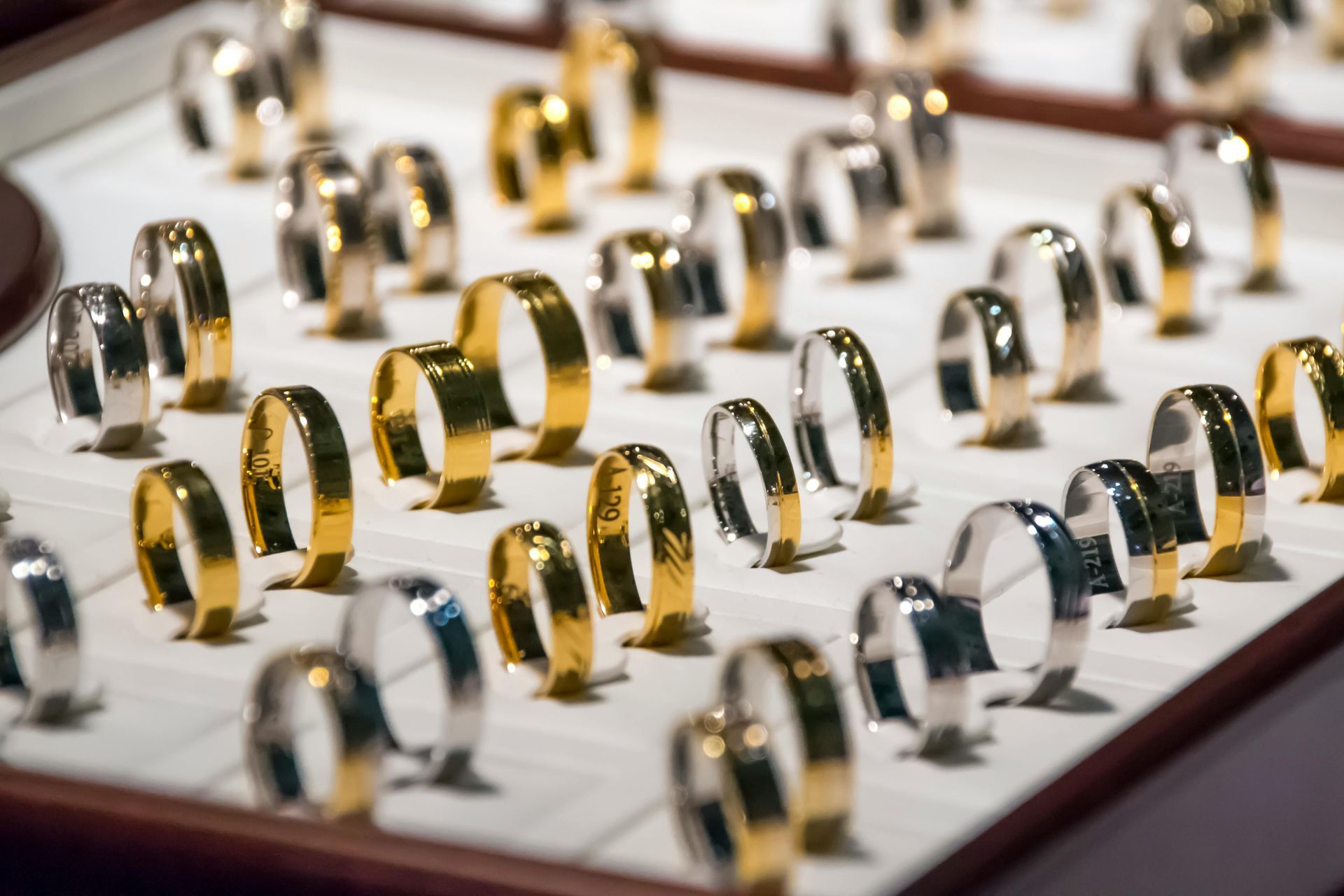 Anillos exhibidos en un joyero; bandas de oro y plata.