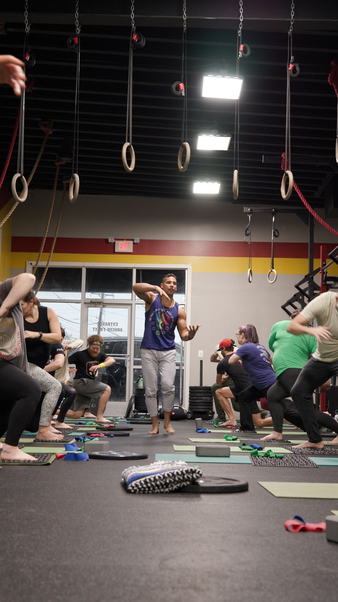 A group of people are doing yoga in a gym.