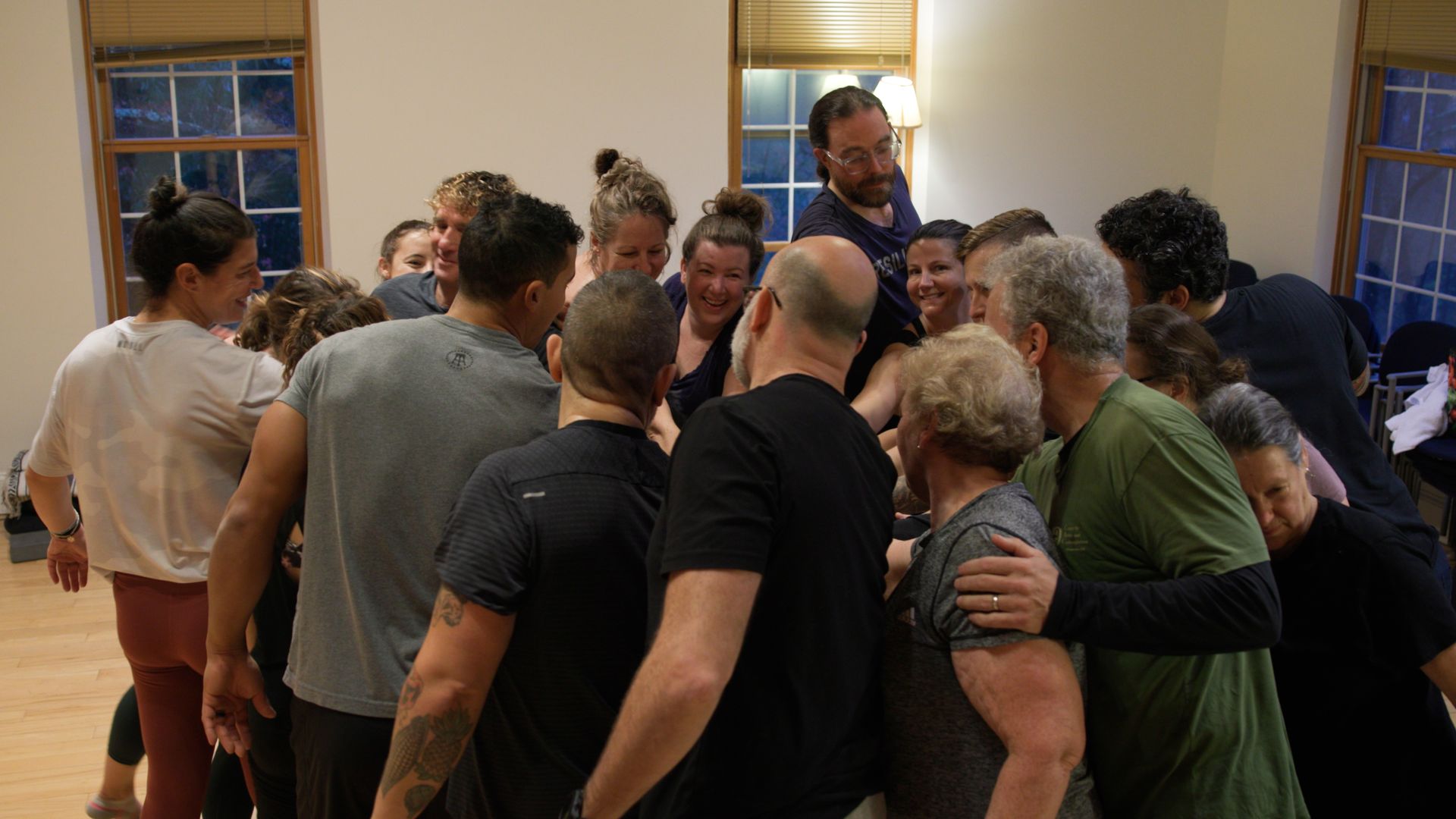 A group of people are standing in a circle in a room.