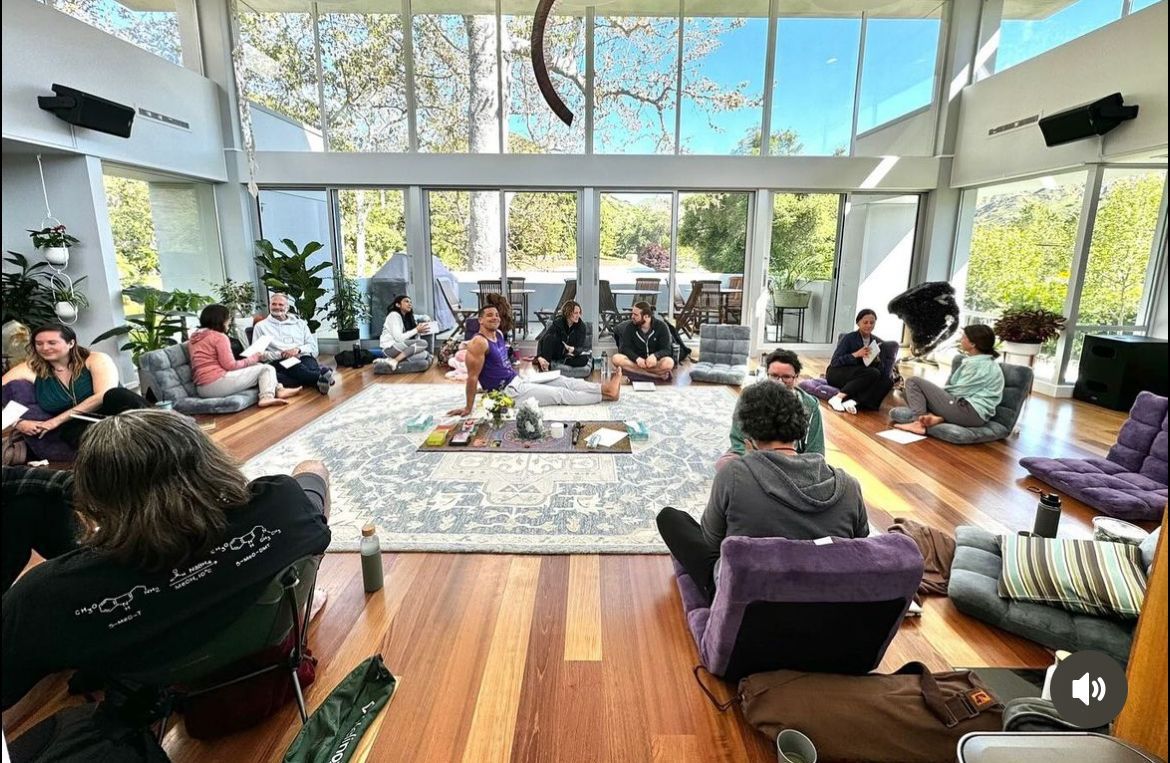 A group of people are sitting in a circle in a living room.