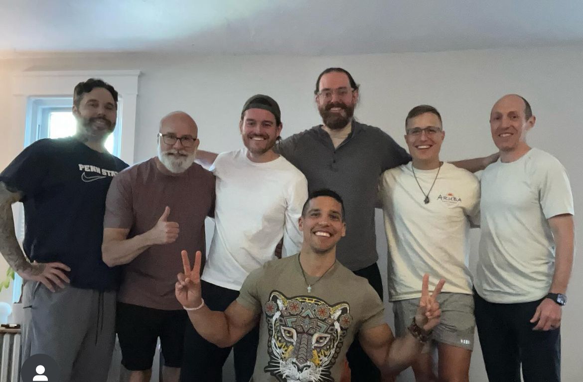 A group of men are posing for a picture and one man is wearing a tiger shirt
