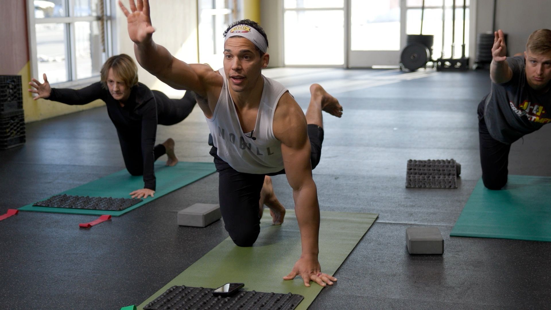 A group of people are doing yoga in a gym.