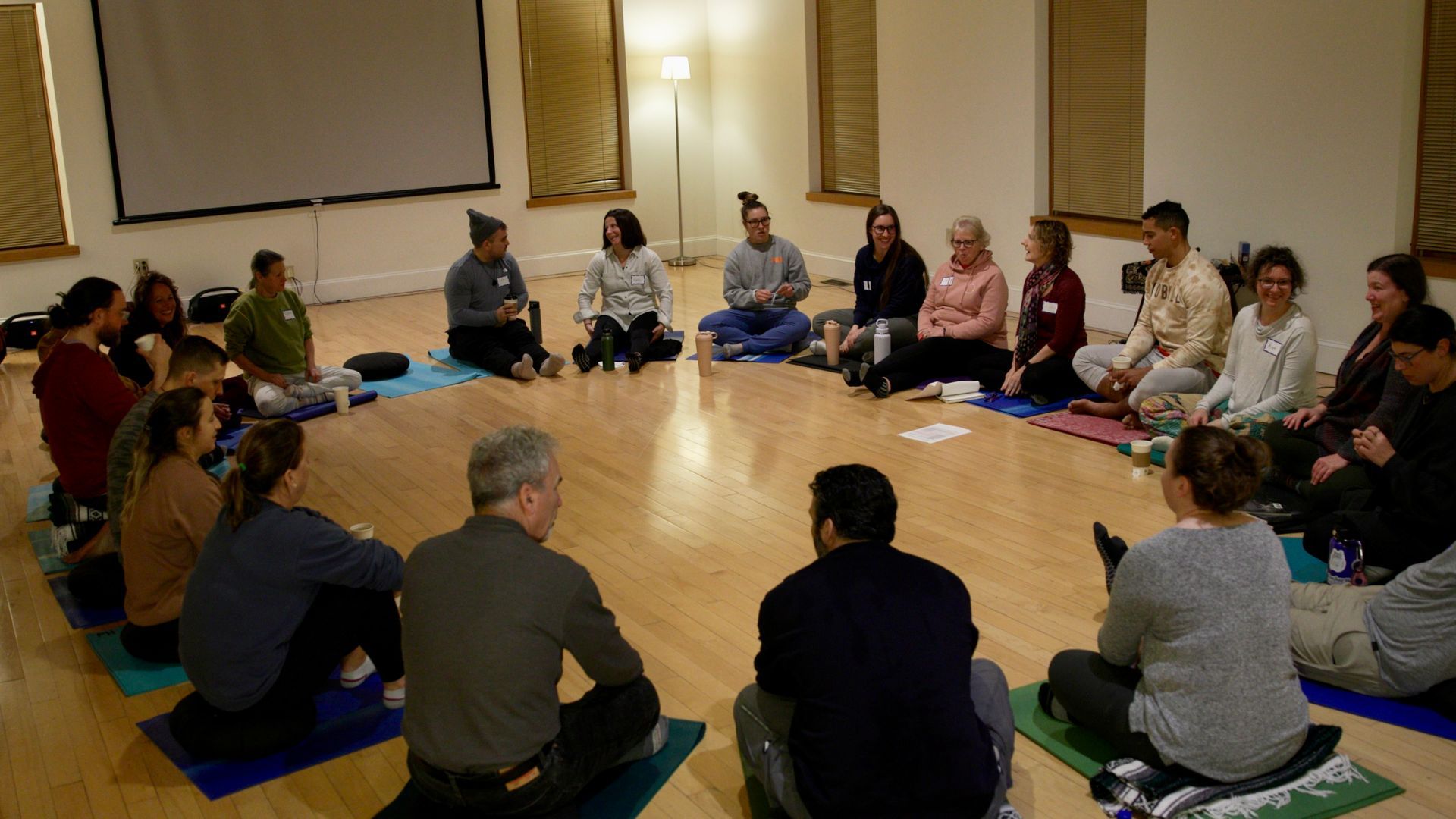 A group of people are sitting in a circle on the floor.