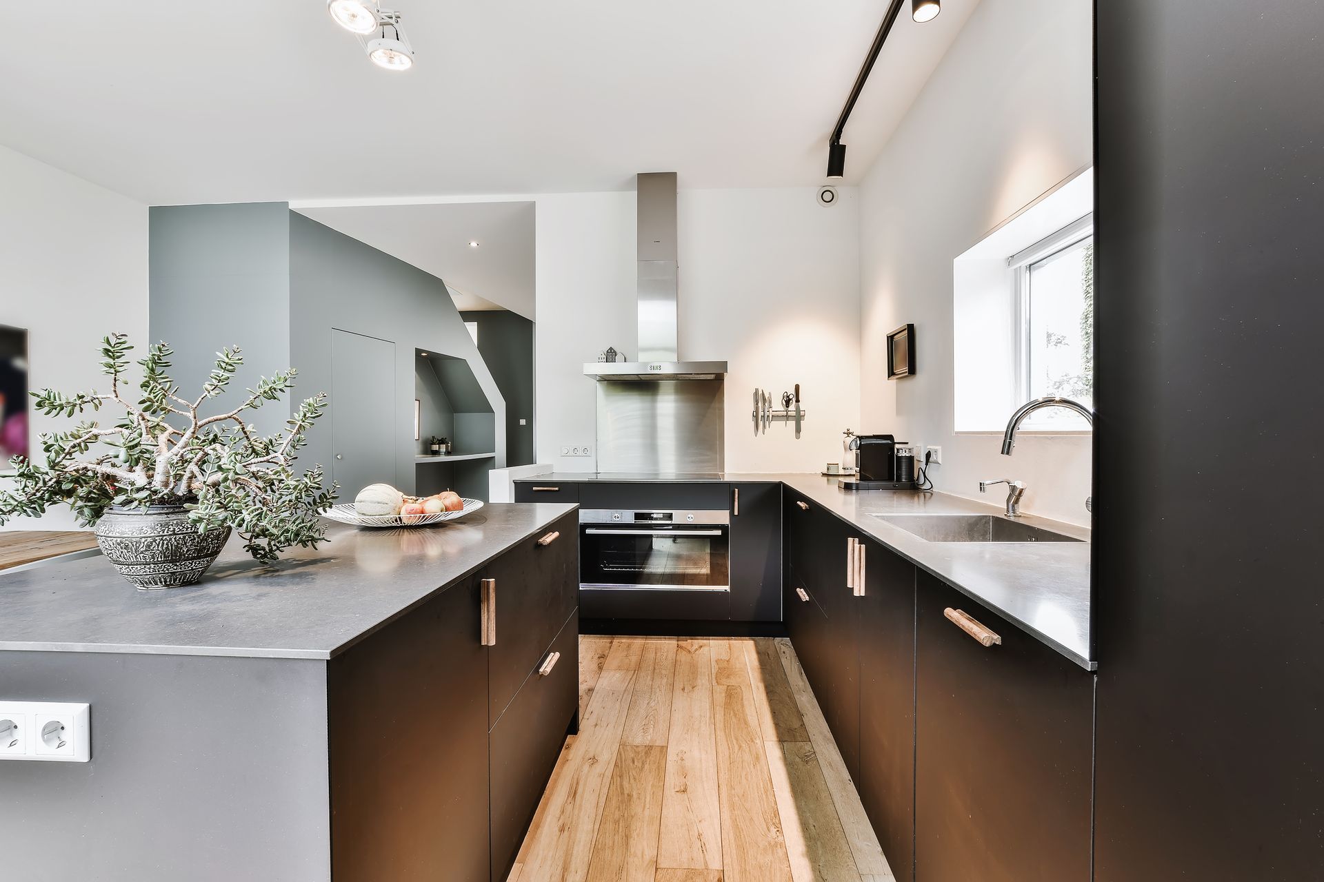 Custom Kitchen Renovation - A kitchen with black cabinets and a wooden floor