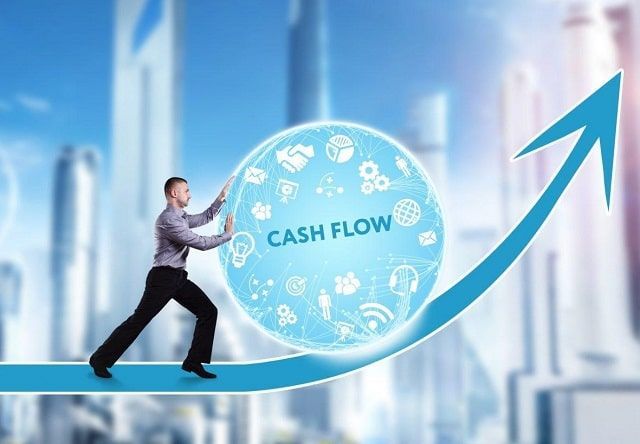 A man is pushing a sphere with the word cash flow on it.