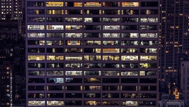 A large building with lots of windows is lit up at night.