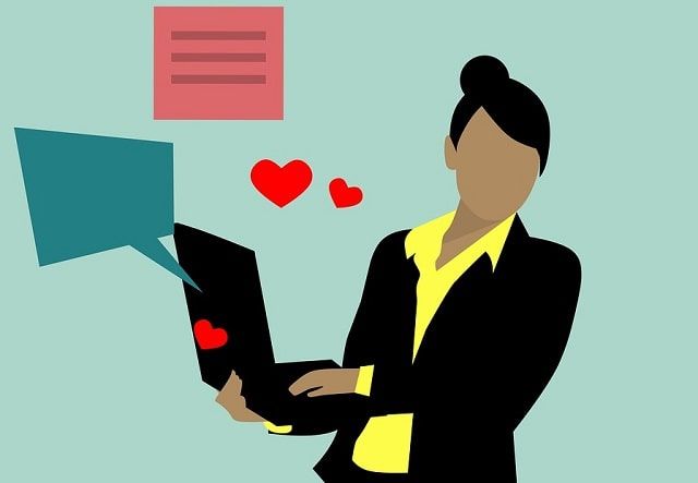 A woman in a suit is using a laptop computer.