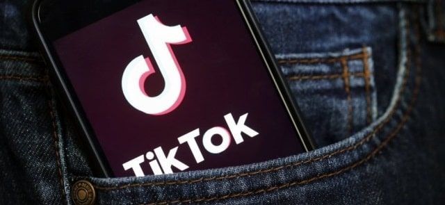 A cell phone is sitting in a pocket of jeans.