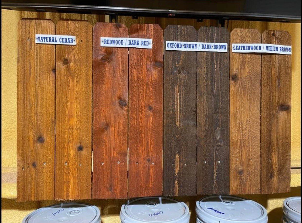 A wooden fence with buckets of paint in front of it