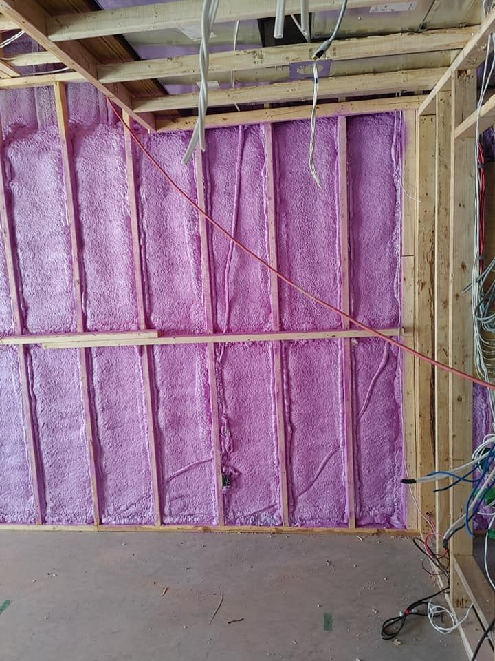 Charpente murale intérieure avec isolation en mousse pulvérisée rose.