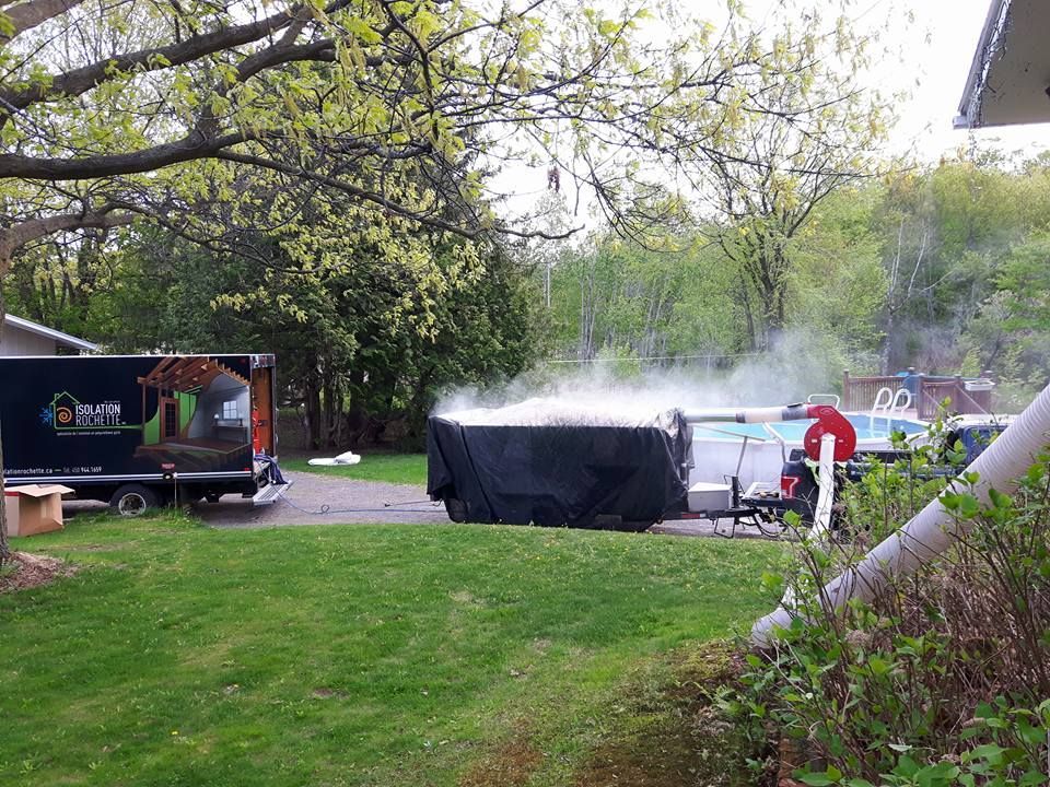 Un jacuzzi dégage de la vapeur dans un jardin, près d'une piscine. Un camion de service est stationné à proximité.