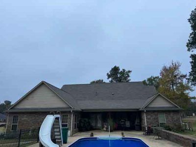 A large house with a pool and a slide in front of it.