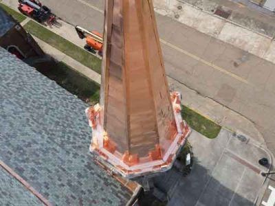 An aerial view of a copper steeple on top of a building.