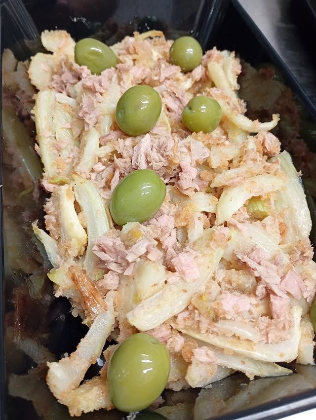 Insalata di tonno con cipolle affettate e olive verdi in un contenitore nero.