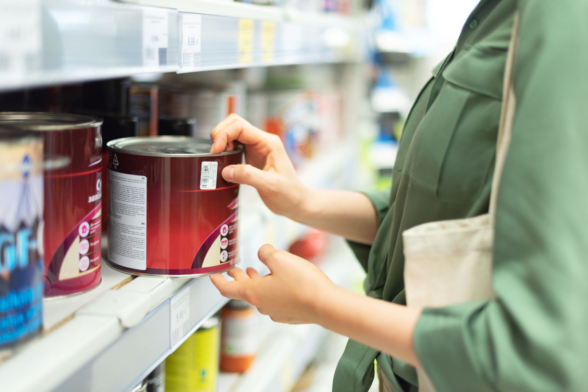 Close-up of a woman choosing a paint from a paint supply.