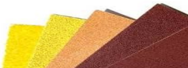 Assorted sandpaper sheets in yellow, orange, and brown.