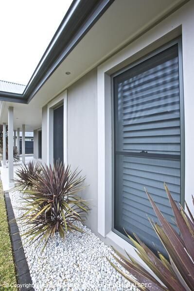 A Man Is Looking Out Of A Window With A Screen On It — Summerland Screens & Awnings In Ballina, NSW
