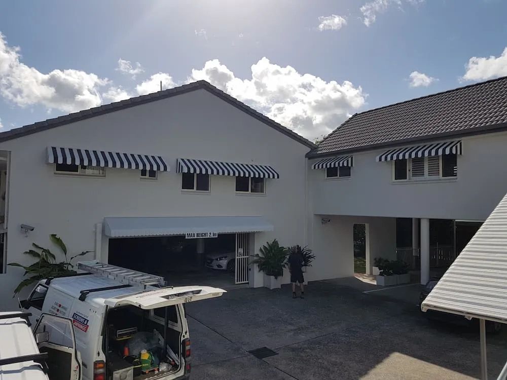 A House With Striped Awnings On The Windows — Summerland Screens & Awnings In Suffolk Park, NSW