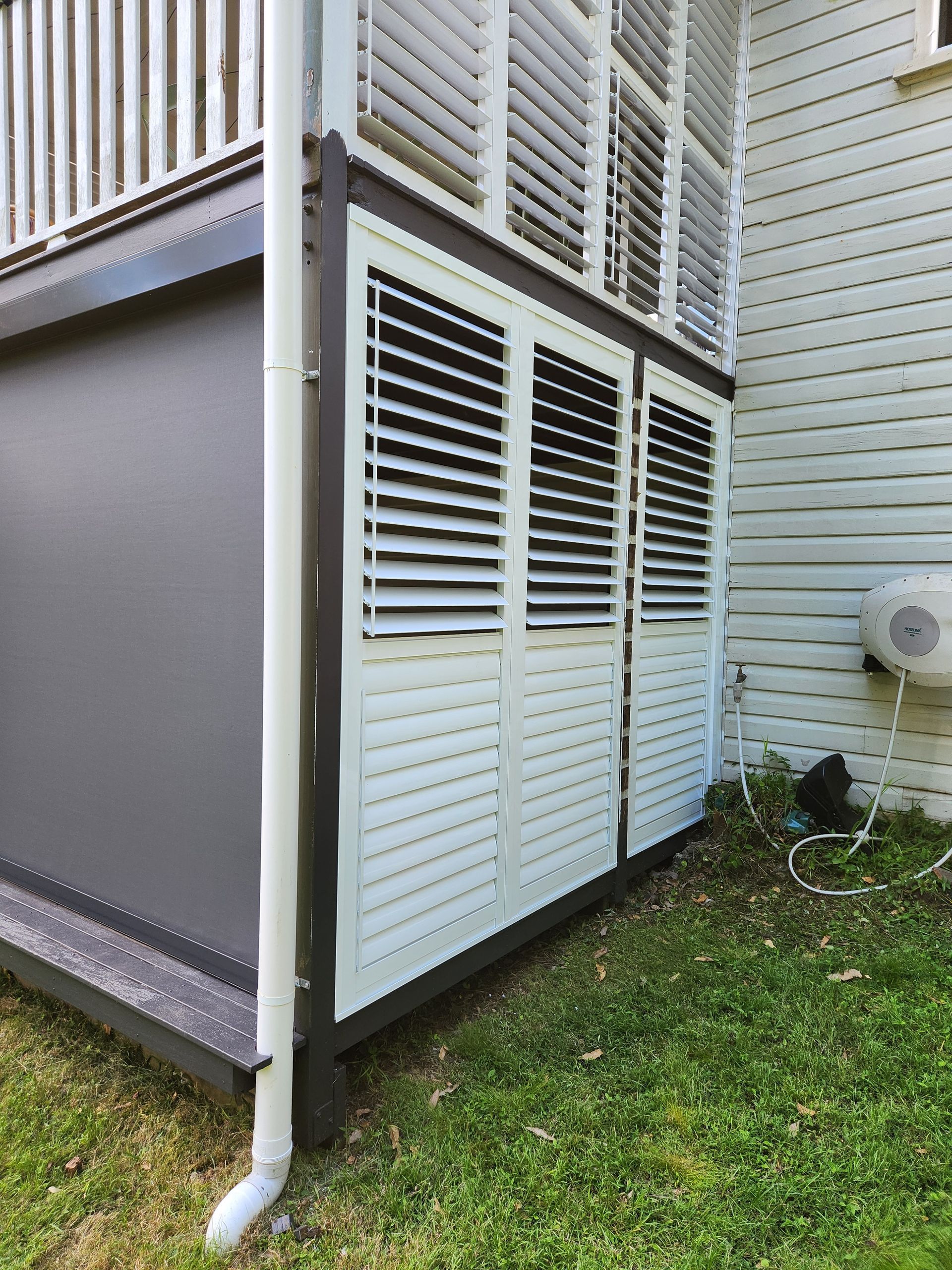 A Grey Building With Black Blinds On The Windows — Summerland Screens & Awnings In Ballina, NSW